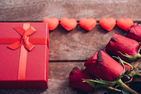 Red hearts, flower roses and gift box on wooden background, valentine day conceptの写真素材