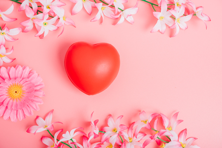 Red heart and flower on pink background with copy space, valentine day conceptの写真素材