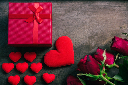 Red hearts, flower roses and gift box on wooden background, valentine day conceptの写真素材