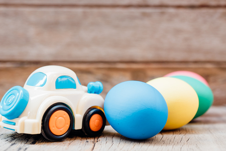 Easter egg and toy car on wooden background, happy easter day conceptの写真素材