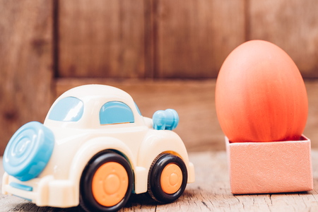 Easter egg and toy car on wooden background, happy easter day conceptの写真素材
