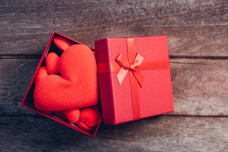 Fabric red heart and gift box on wooden background, valentine day conceptの写真素材
