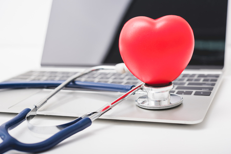 Health stethoscope and red heart on keyboard of laptop computer, medical conceptの写真素材