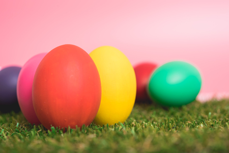 Colorful Easter eggs clean on grass and pink background, easter day conceptの写真素材