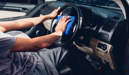 Worker man cleaning dust interior by cloth microfiber inside car after washの写真素材