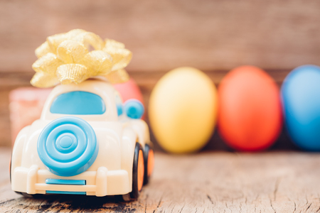 Easter egg and toy car on wooden background, happy easter day conceptの写真素材