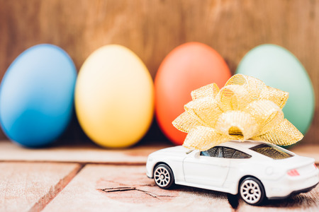 Easter egg and toy car on wooden background, happy easter day conceptの写真素材