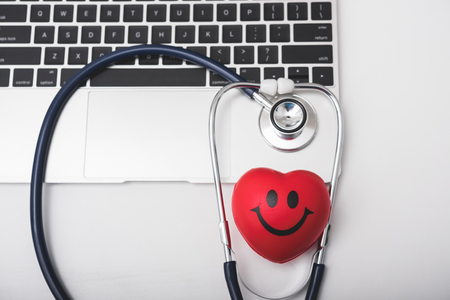 Health stethoscope and red heart on keyboard of laptop computer, medical conceptの写真素材