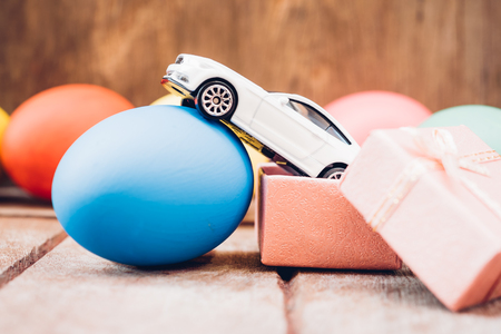 Easter egg and toy car on wooden background, happy easter day conceptの写真素材