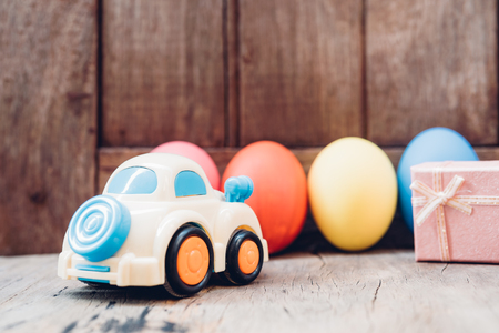 Easter egg and toy car on wooden background, happy easter day conceptの写真素材