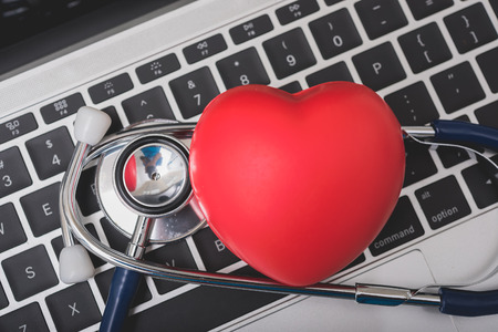 Health stethoscope and red heart on keyboard of laptop computer, medical concept