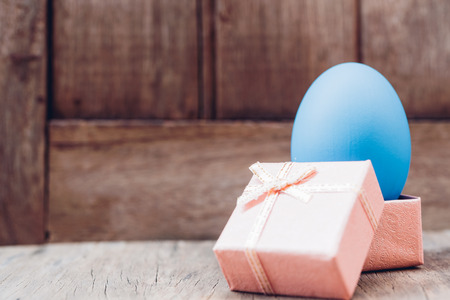 Easter egg and gift box on wooden background, happy easter day conceptの写真素材