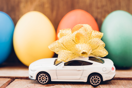 Easter egg and toy car on wooden background, happy easter day conceptの写真素材