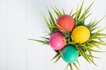 Top view of Easter eggs clean in grass on white wooden background, easter day conceptの写真素材