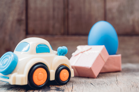 Easter egg and toy car on wooden background, happy easter day conceptの写真素材
