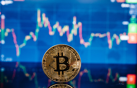 Bitcoin, virtual golden bit coin money on candle stick graph chart backgroundの写真素材