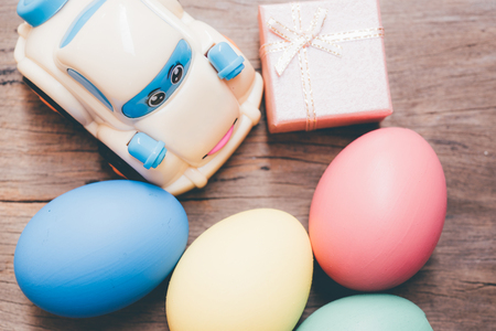 Easter egg and toy car on wooden background, happy easter day conceptの写真素材