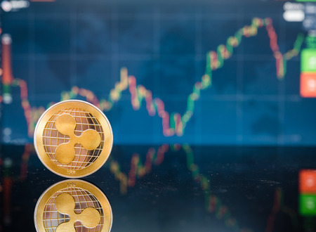Bitcoin and XRP, gold virtual bit coin and xrp money currency on digital candle stick graph chart backgroundの写真素材