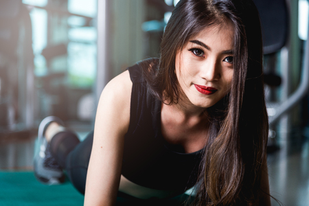 Asian woman exercise plank physical planking workout at fitness gymの写真素材