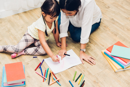 Child kid girl kindergarten drawing teacher education mother with beautiful mother at interior room homeの写真素材