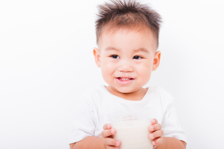 Asian portrait child boys 1 year 6 months drinking milk on glass on white backgroundの写真素材