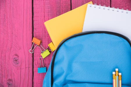 Top view Blue bag backpack for education children on pink wooden  background back to school conceptの写真素材