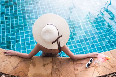 Young back woman in bikini luxury swimming pool drink cocktail, vacation summer holiday conceptの写真素材