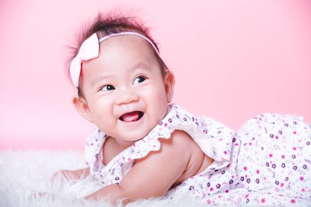 Asian girl cute baby smiling face on pink backgroundの写真素材
