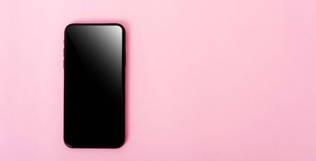 Top view of modern technology smart phone mobile on pink background with copy spaceの写真素材