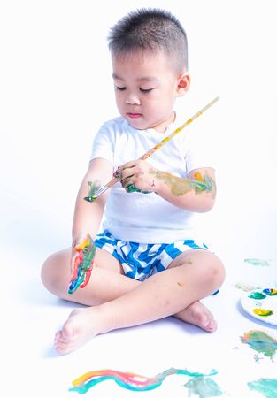 Happy asian baby childhood use paintbrush draw water color or fingerpaint on hand and arm by oneself, Baby 2-3 yearsの写真素材