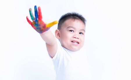 Happy asian childhood kid smile on education art he show hand with water color or finger paint on hands white background, Baby 2-3 yearsの写真素材