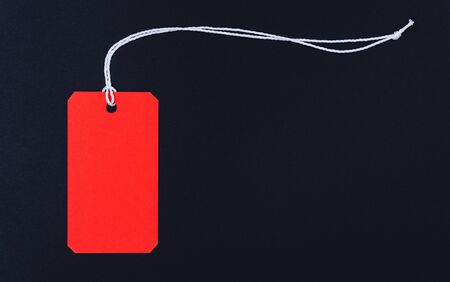 Red tag label on black background, blank copy space for you workの写真素材