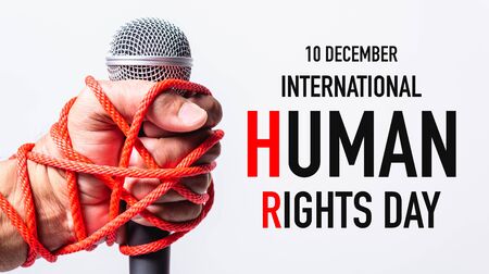 Hand holding microphone and have roped on fist hand with 10 december international HUMAN RIGHTS DAY text on white background, Human rights day conceptの写真素材
