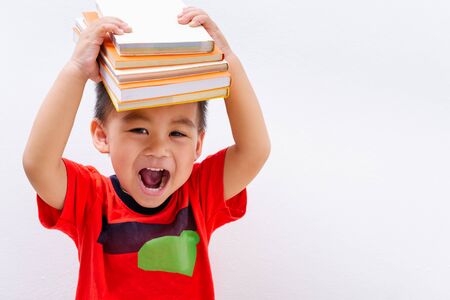 Back to school, Asian student boy kid stack book balanced on head and on white wall background, Education conceptの写真素材