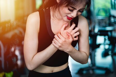 Woman injury pain chest attack heart after workout training exercise at fitness gymの写真素材