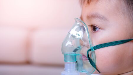 Closeup asian face little children boy sick he using steam inhaler nebulizer mask inhalation oneself, health medical careの写真素材