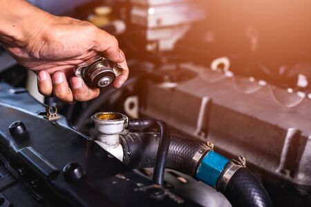 Hand of auto mechanic technician service check cooling water he open radiator cap the in garage