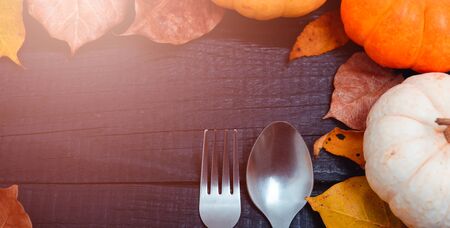 Fall Thanksgiving and Halloween pumpkins and dry leaves on wooden background, top view shot