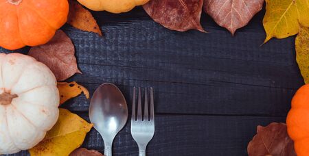 Fall Thanksgiving and Halloween pumpkins and dry leaves on wooden background, top view shotの写真素材