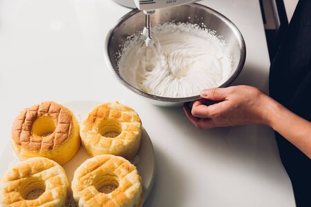 Woman beat dough mixer by machine in bowl at her kitchen