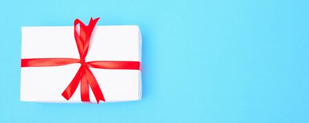 Happy New Year and Christmas 2020 or valentine day, top view craft paper wrapped present white gift box craft on blue background with copy space for your textの写真素材