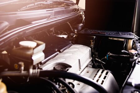 Laptop computer on car mechanic engine for service at workshopの写真素材