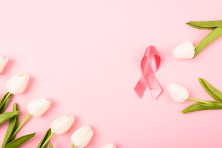 Breast cancer month concept, flat lay top view, pink ribbon and Tulip Flower on pink background with copy space for your textの写真素材