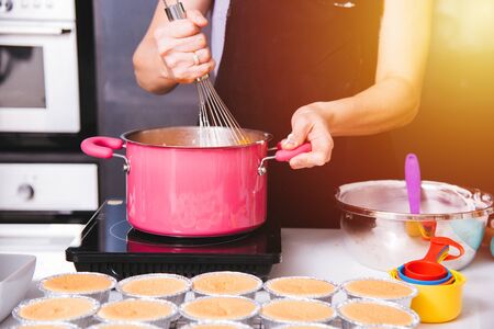 Beautiful woman cooking whisk dough in bowl manual by hands at homemade