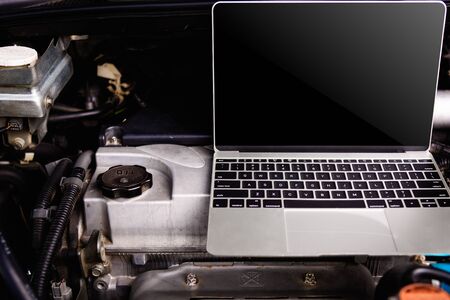 Laptop computer on car mechanic engine for service at workshopの写真素材