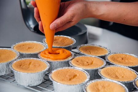 Woman during making decorating cooking bakery cake at homemade