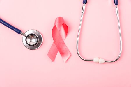 Breast Cancer Awareness Month Health concept, top view flat lay pink ribbon and stethoscope on pink background with copy space for your textの写真素材