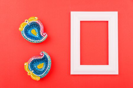 Happy Diwali Day, Flat lay top view Colorful Clay Diya lamps and photo frame on red background and copy space for your textの写真素材