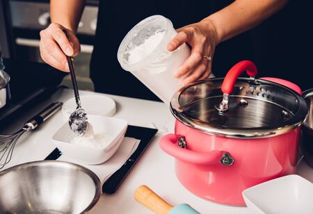 Woman during making pour measure dough before cooking bakery at homemadeの写真素材