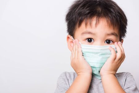 Closeup Asian face, Little children boy sick he using medicine healthcare mask on white background with copy space, health medical careの写真素材